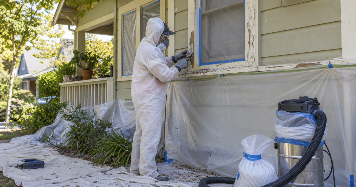 Lead-safe exterior paint preparation on an older Davis home with containment sheeting, protected windows, scraping, PPE, and HEPA cleanup equipment